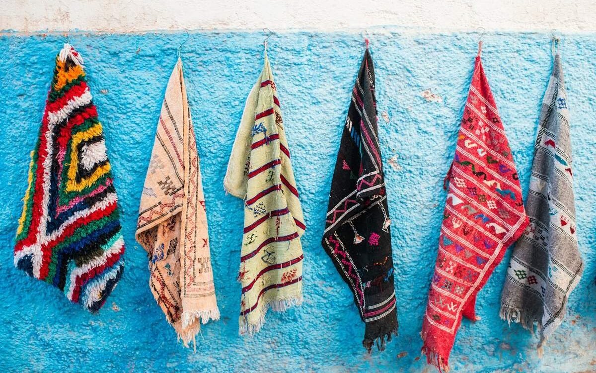 Tapis berbères suspendus sur un mur bleu